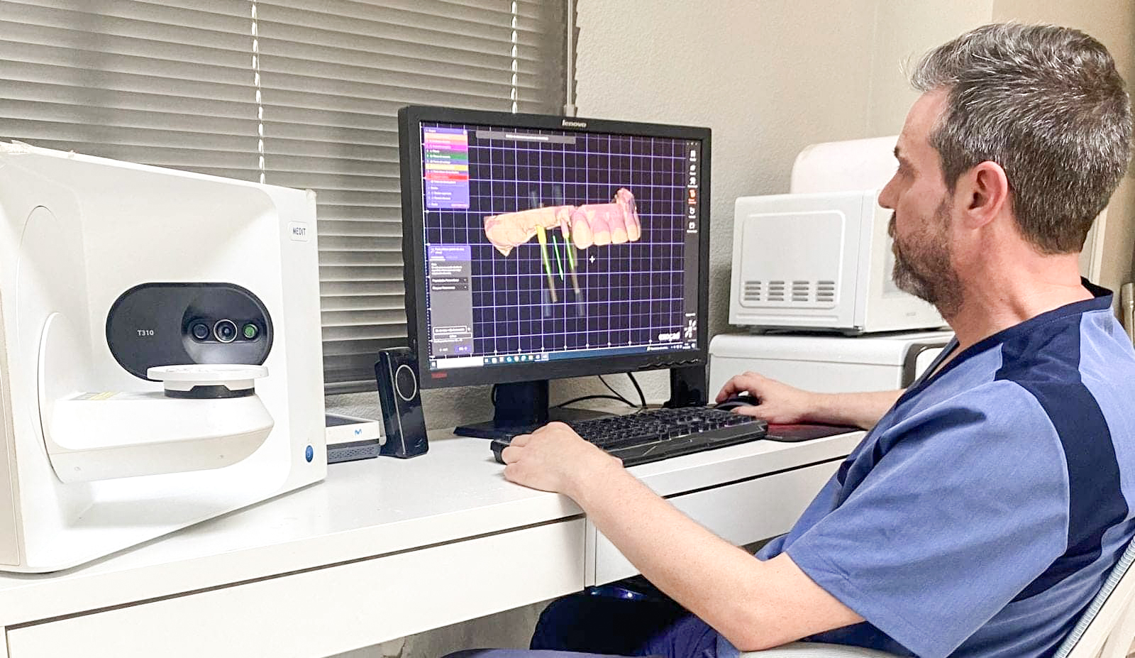 Odontologo protesikoa hortz-protesi baten diseinua gainbegiratzen ari da ordenagailuan.